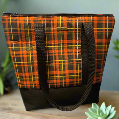 Orange and black plaid tote bag with black strap handles